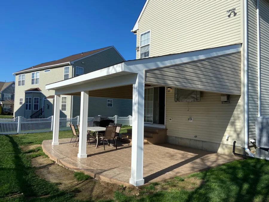 new concrete patio with over hang cream siding 
