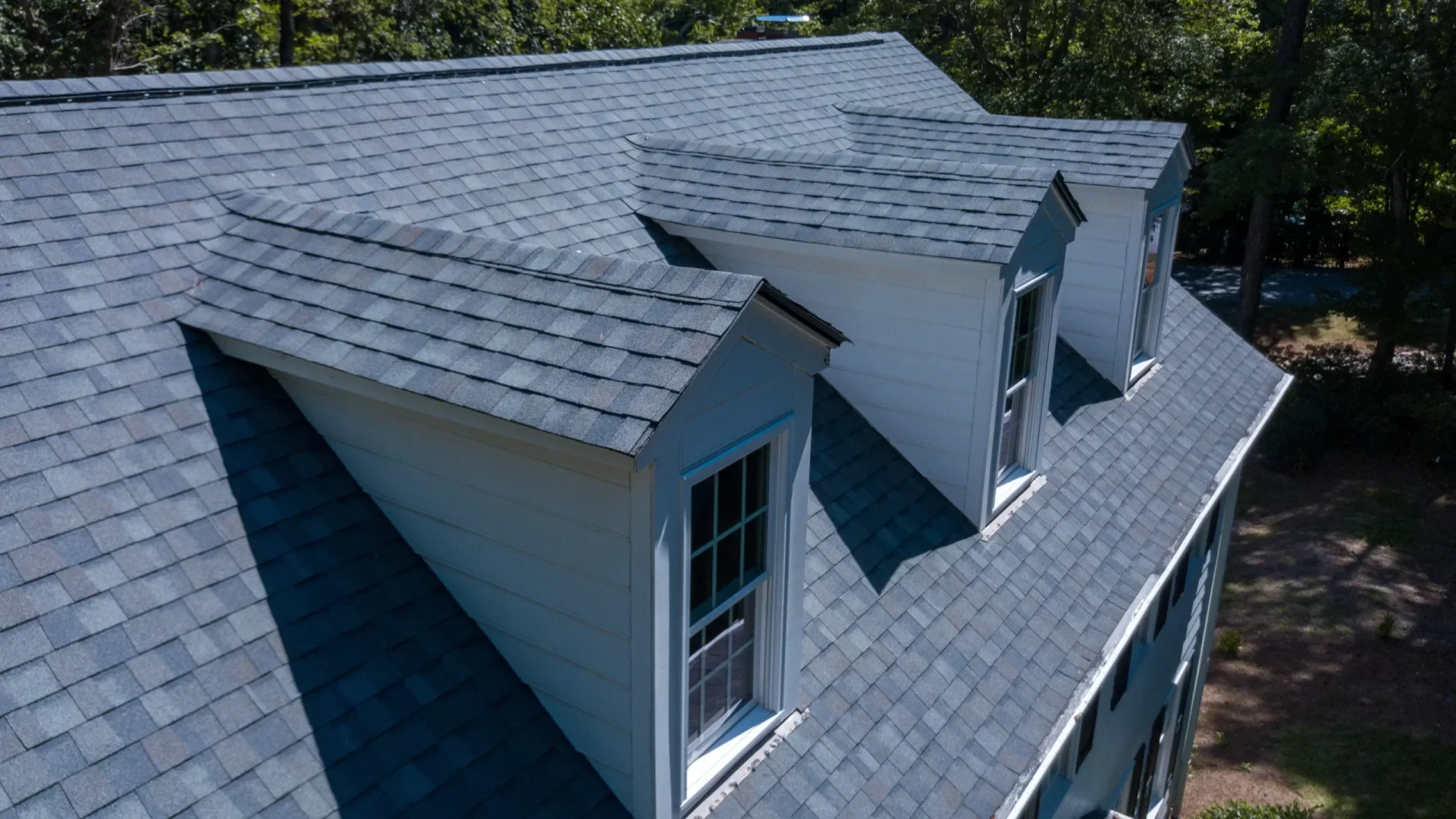 Blue Shingles Roof Replacement Deptford Nj Ameritech Services Scaled The roof of a house with three windows on the roof and blue shingles in Deptford, NJ by Ameritech Services