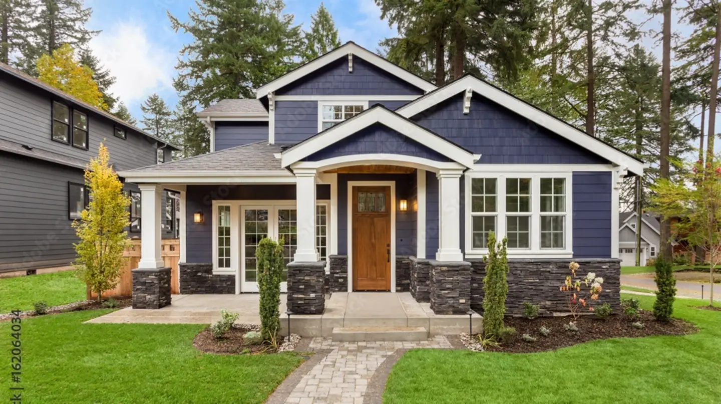 A blue-sided home with white trim, white windows, and a gray asphalt shingle roof