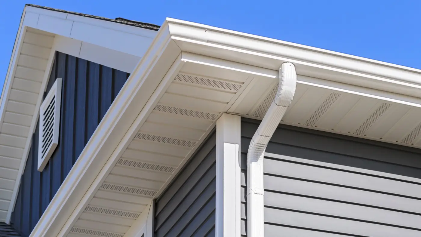 A closeup of a white gutter system on a house with blue siding in Blackwood, NJ, by Ameritech Services