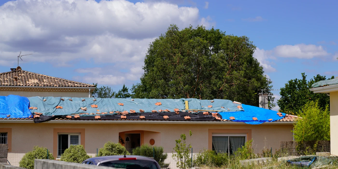 View of tarps on a roof as Ameritech NJ repairs it after wind damage.