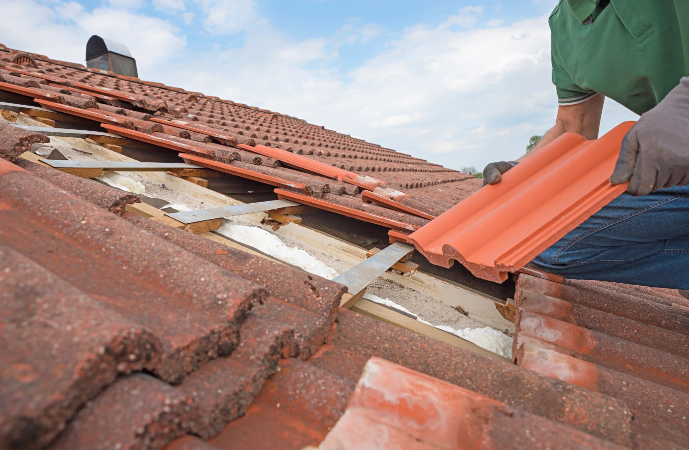 An Ameritech Services roofer in South Jersey replaces broken roof shingles on the rooftop with new ones.