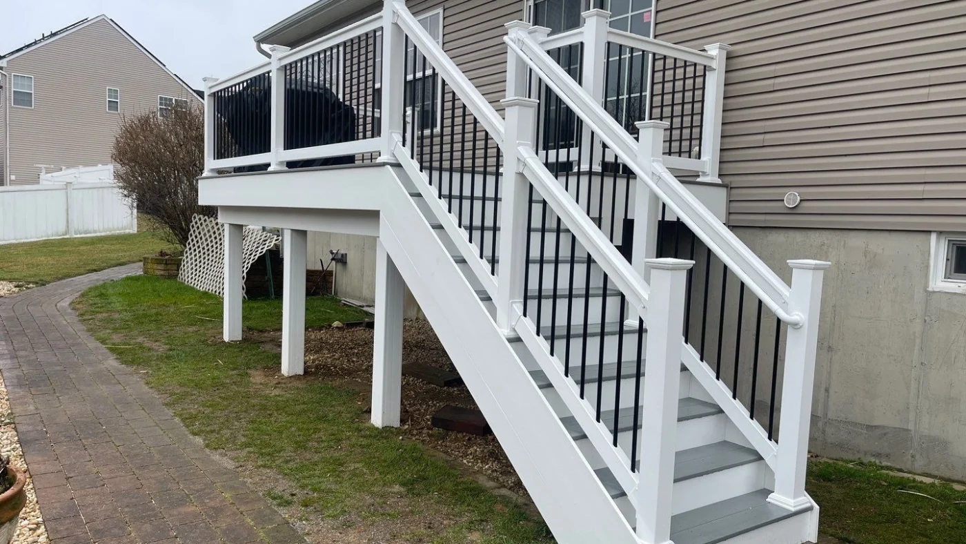 A staircase leading up to a deck on a brown-sided home