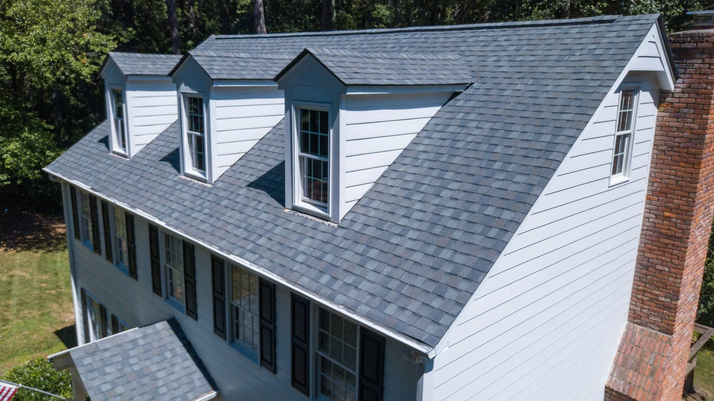 A white-sided home with a gray asphalt shingle roof