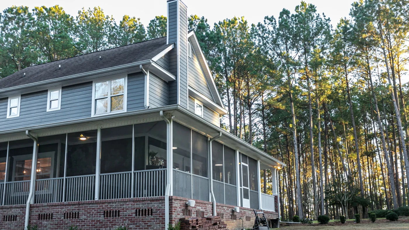 A blue-sided home surrounded by trees