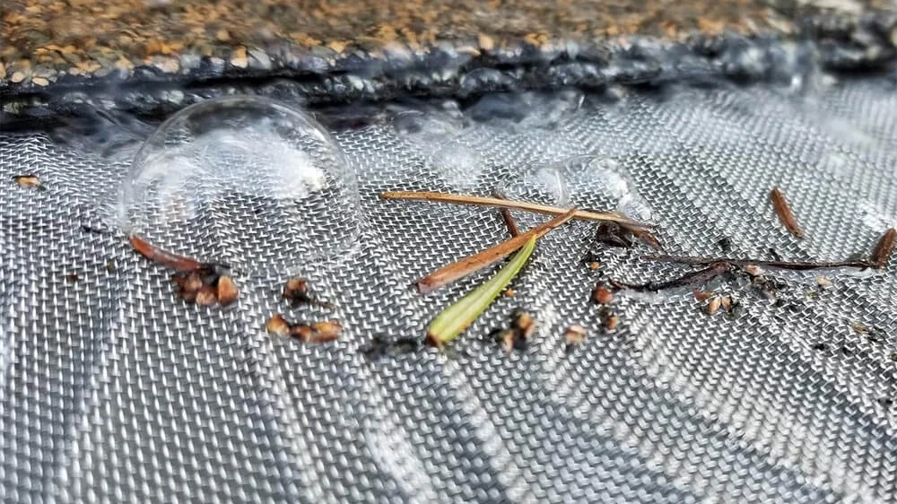 Closeup of a gutter guard blocking tiny debris from entering the gutter