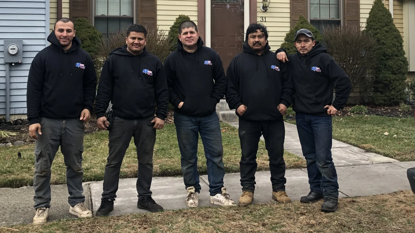 The Ameritech Services Team standing next to a completed roofing project