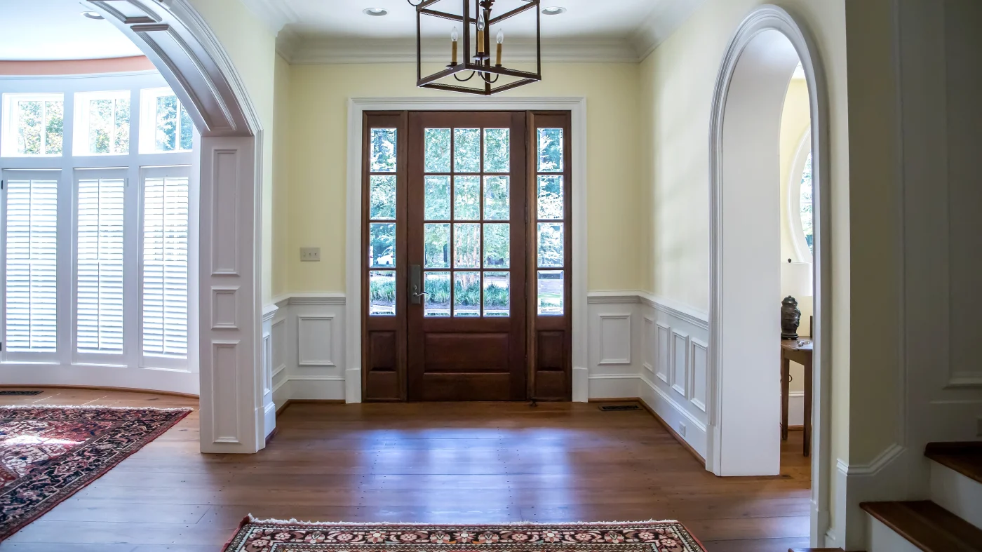 Two windows inside a home with white trim looking out towards a backyard filled with bushes in Marlton, NJ, by Ameritech Services.