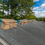 A roof with bundles of shingles on the peak ready for a roof replacement