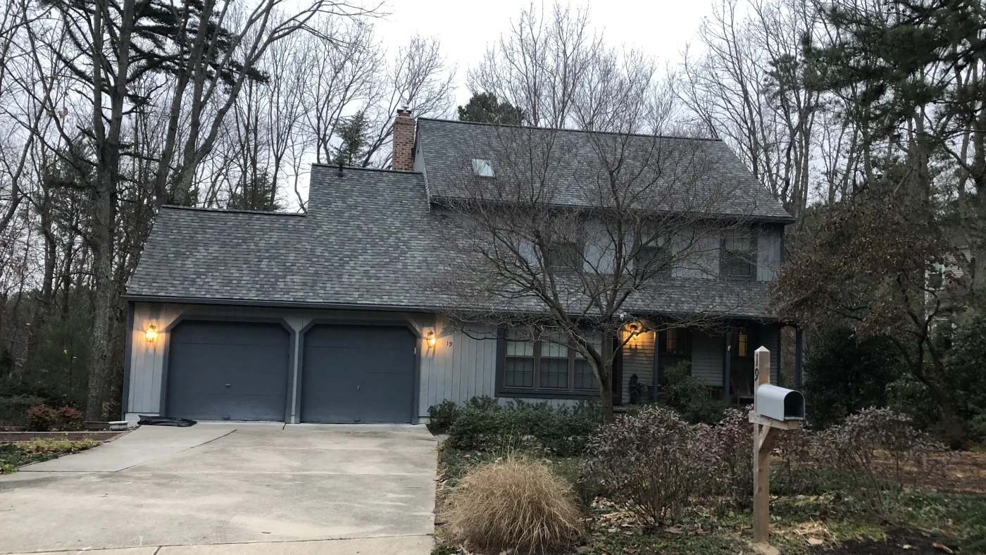 A two-story home with gray asphalt shingles