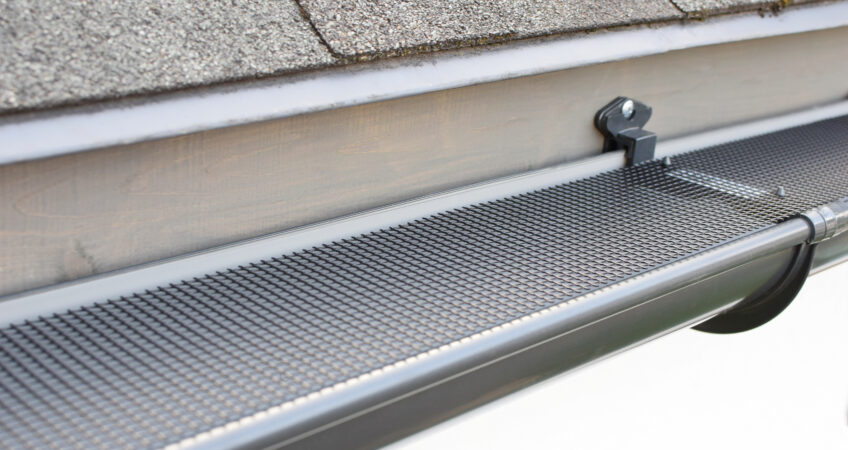 Gutters On The Side Of AHome With Gutter Guards Installed On Them
